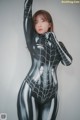 A woman in a black and silver spider suit posing for a picture.