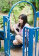 A young woman sitting on a playground equipment.