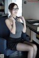 A woman sitting on a blue chair in a room.