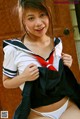 A woman in a school uniform posing for the camera.