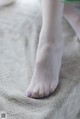 A close up of a woman's bare feet on a bed.