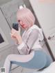 A woman with pink hair is taking a selfie in a bathroom.