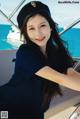 A woman in a sailor's hat sitting on a boat.