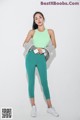 A woman in a green sports bra top and green leggings.