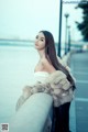 A woman in a fur coat leaning against a railing.