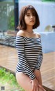 A woman in a striped bathing suit posing for a picture.