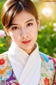 A woman in a colorful kimono poses for a picture.