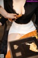 A woman in a black shirt and white skirt holding a wallet.