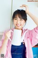 A woman holding a white teapot in her hands.